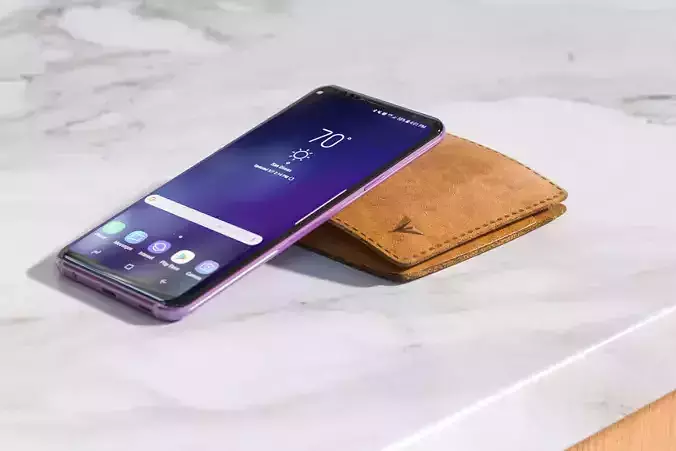 Smartphone next to brown leather wallet