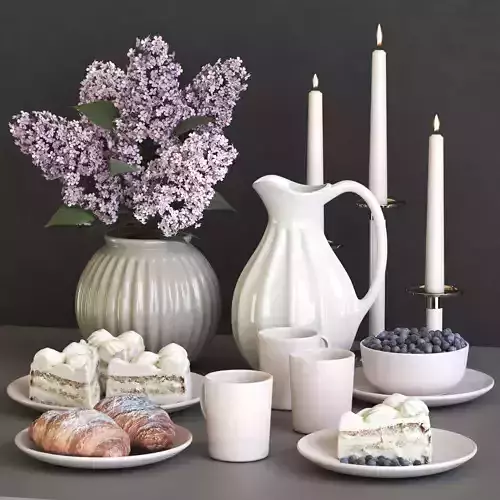 A set of dishes with a croissant and cake and lilac