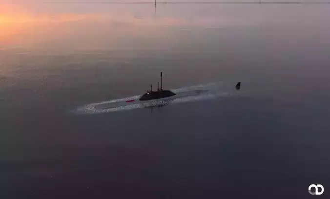 Submarine floating in ocean at sunset