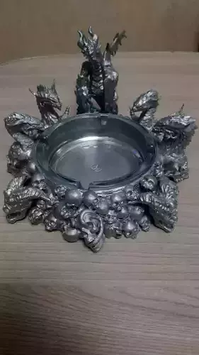 an ashtray with dragons and skulls