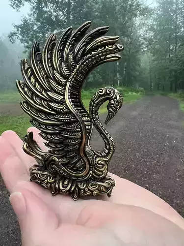 Swan print bronze in hand of person