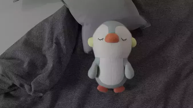 Plushie penguin stuffed animal on bed