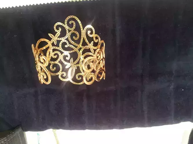 YD113 gold cuff bracelet on velvet bag