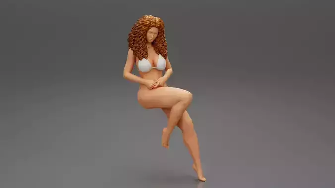 Young girl sitting in a chair in a bikini with long curly hair