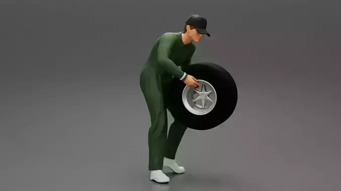 Auto mechanic walking and carrying tyre