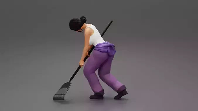 Woman farmer working field with a rake