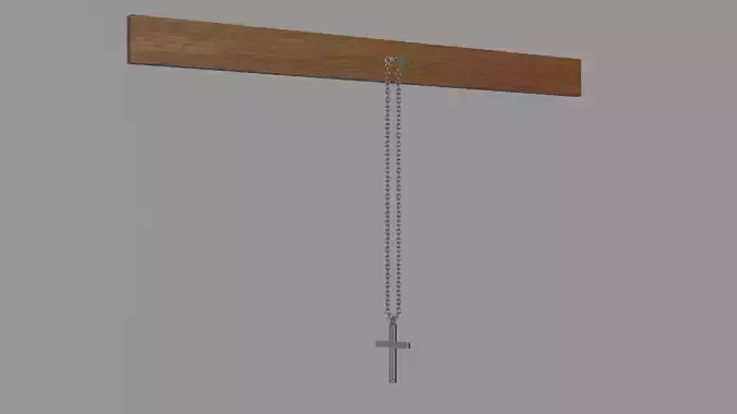 A cross on a chain that hangs on a nail nailed to the board