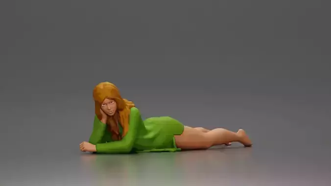 Girl with long hair in green dress lying with calm on the beach