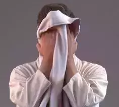Man in bathrobe drying his face